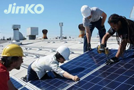 Jinko solar contractors installing panels on commercial building