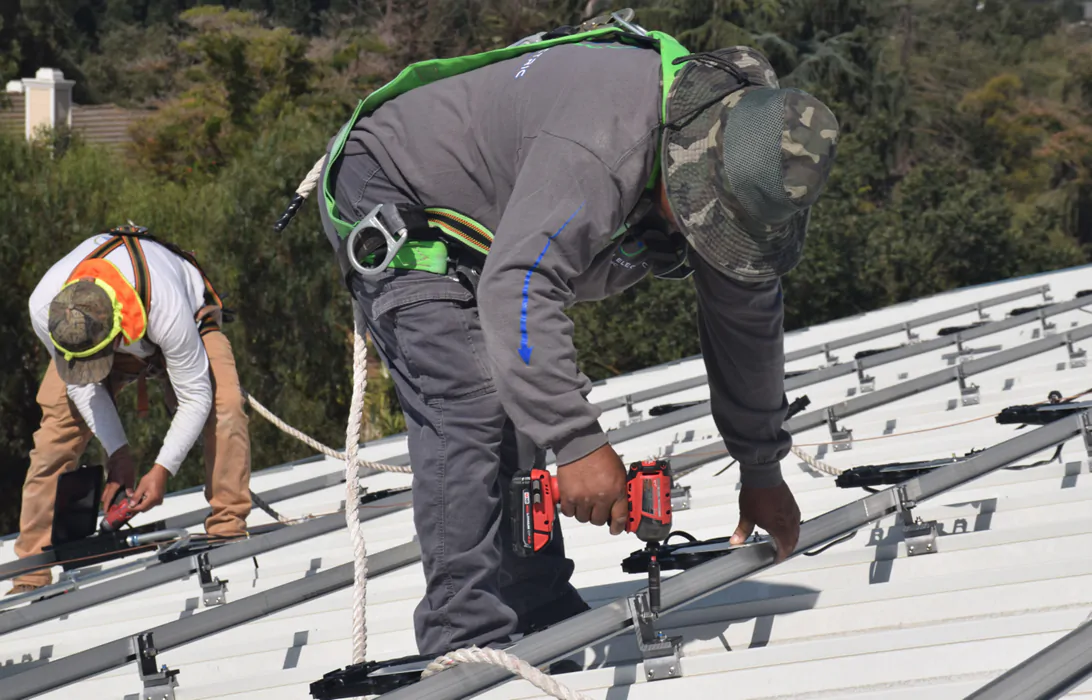 Solar installers working on a roof array